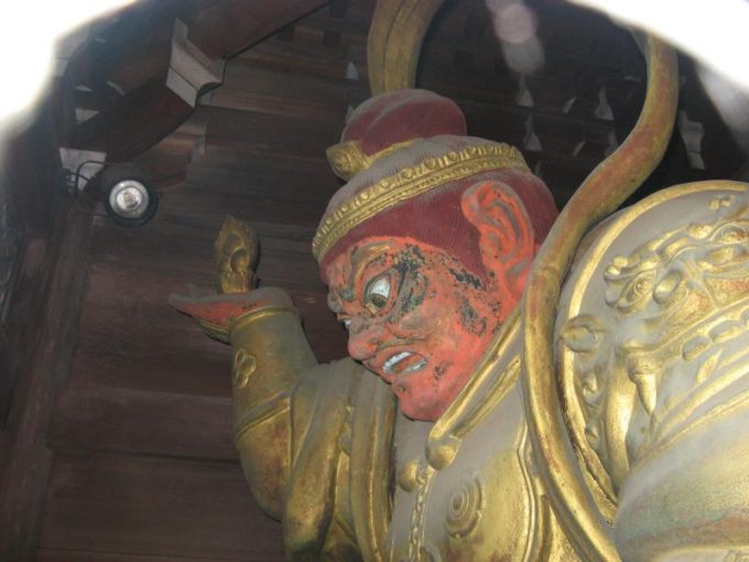 薬王院の門にある赤い顔の像